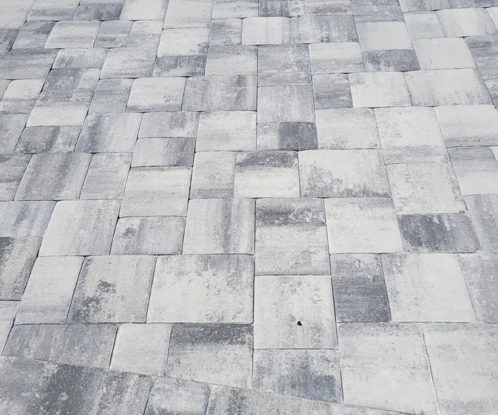 Finished gray paver patio beside a house