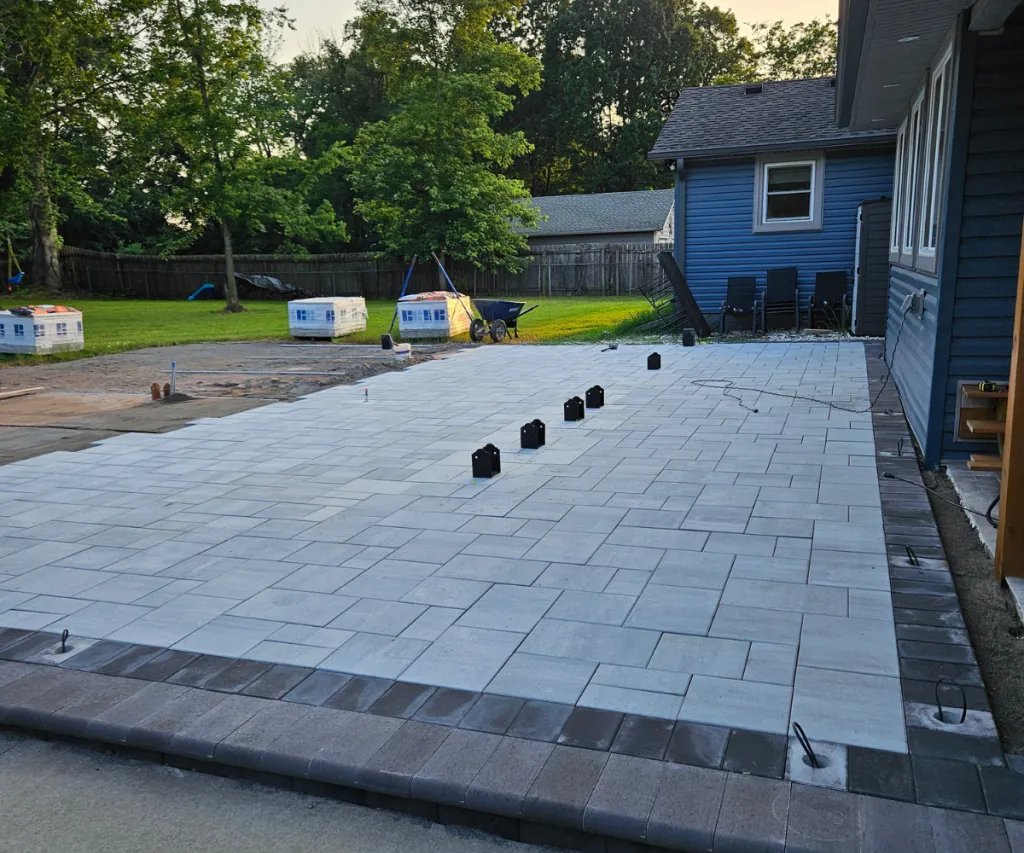 Gray pavers being laid beside a house