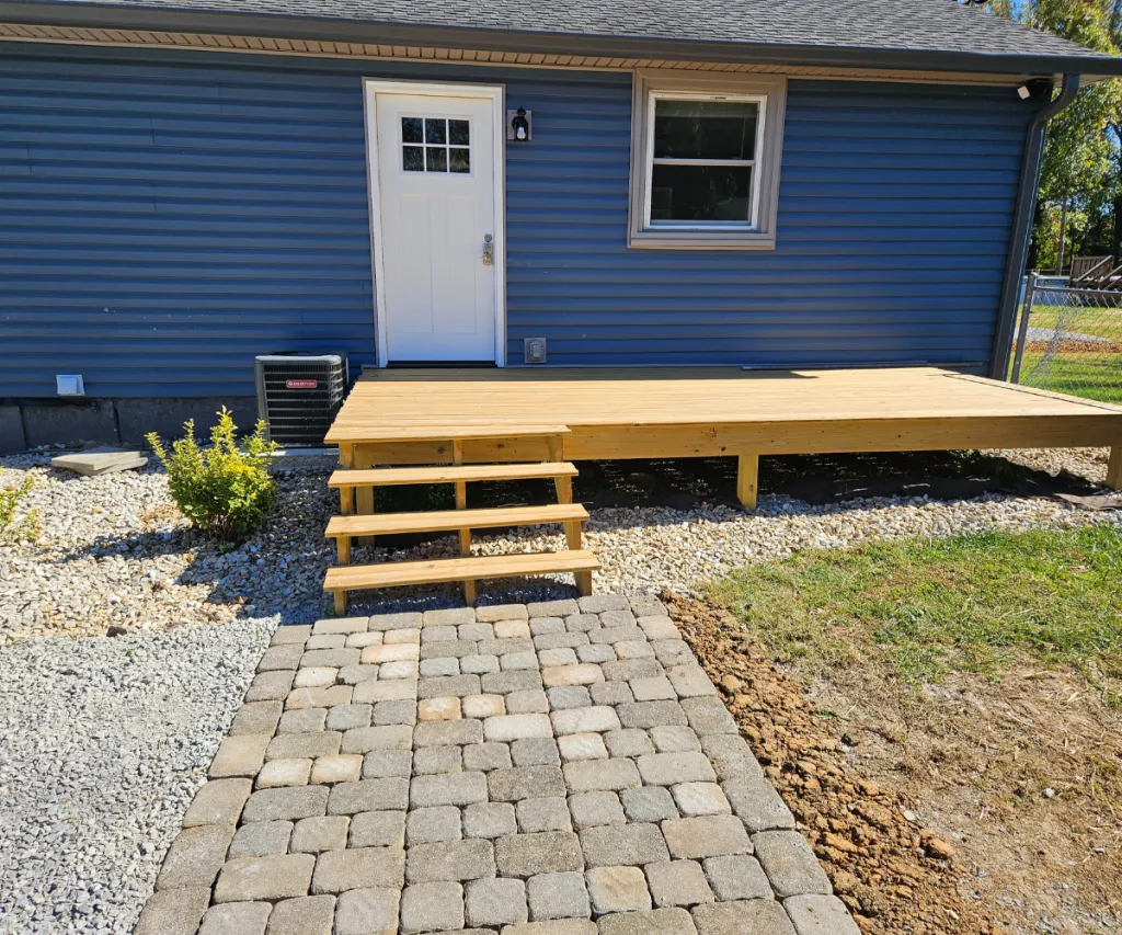 Steps up to a shed with a paver walk leading to them